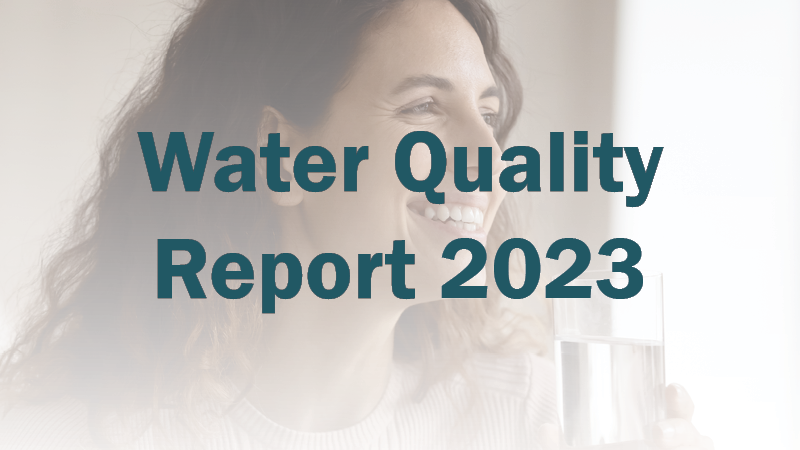 Smiling woman holds a glass of water. Text overlay reads &quot;Water Quality Report 2023&quot;